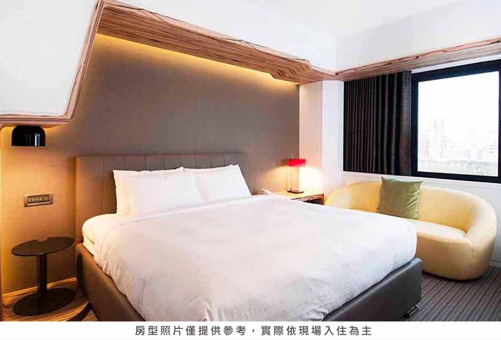 a bedroom with a large white bed and a window at Royal Hotel Group- Central Park Branch in Kaohsiung