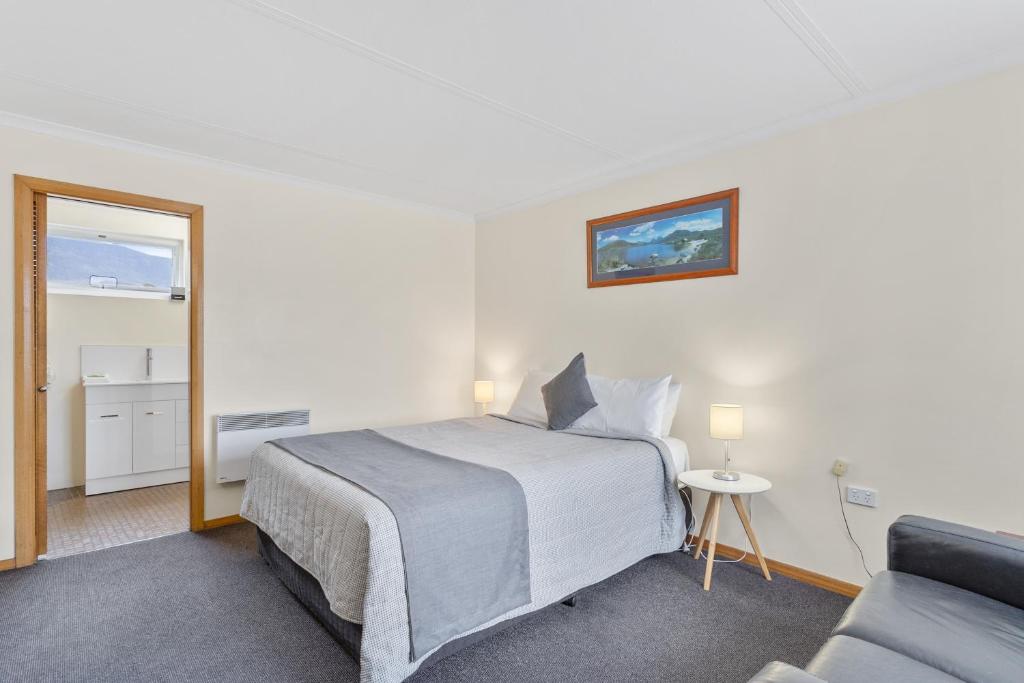 um quarto com uma cama e um sofá em Martin Cash Motel em Hobart