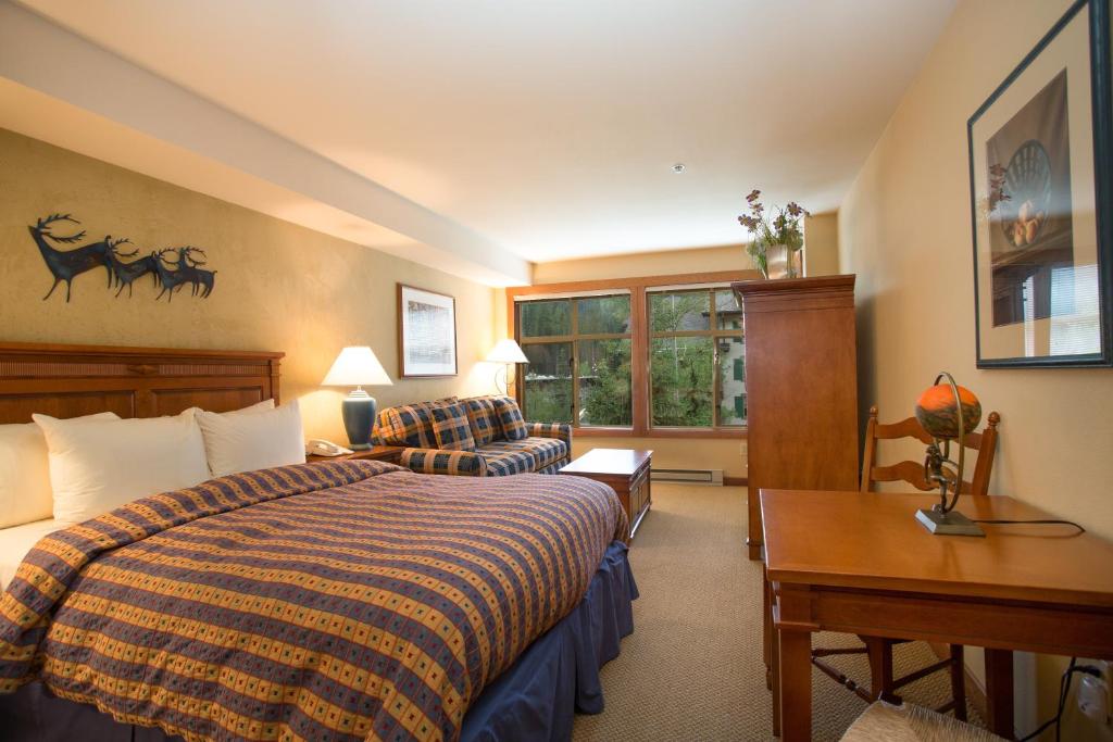 um quarto de hotel com uma cama e dois sofás em 3309B - Queen Standard Powderhorn Lodge condo em Solitude
