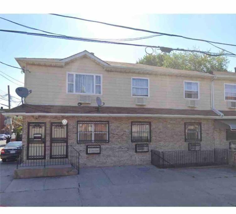 a large brick house with windows on a street at Large 3-Bedrooms/2-Bath Apt, One Block to Train in Brooklyn