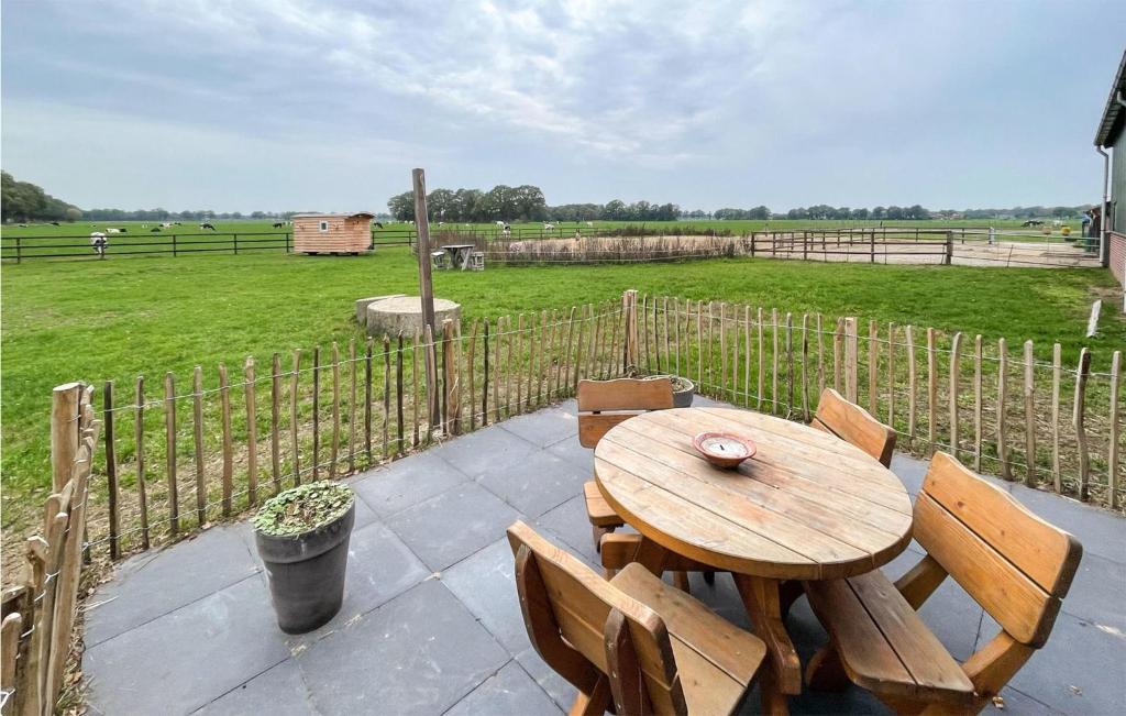 una mesa de madera y sillas en un patio con un campo en Pet Friendly Home In Beltrum With House A Panoramic View en Beltrum