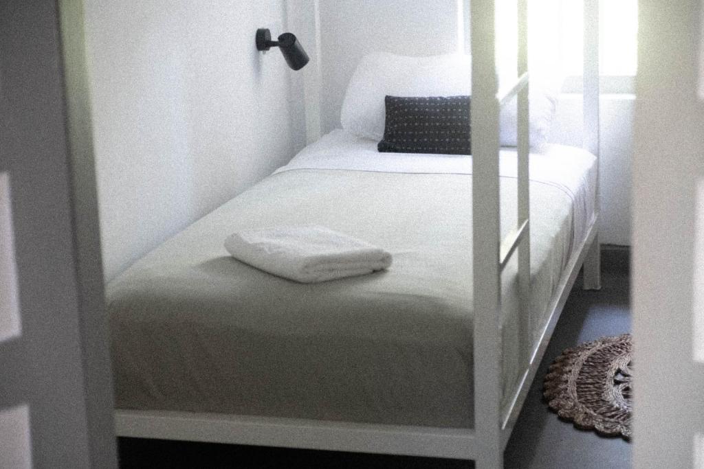 ein kleines Schlafzimmer mit einem Etagenbett und einem weißen Bettvisor in der Unterkunft Clics Coliving & Coworking in Hiriketiya