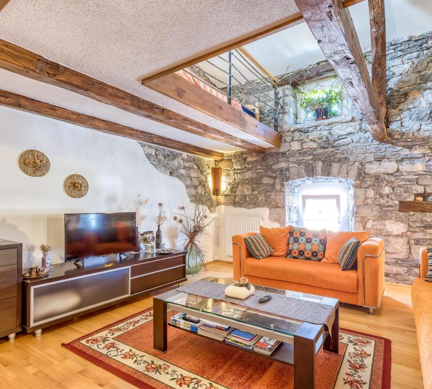 uma sala de estar com uma parede de pedra em Countryside Child Friendly Homes Dutovlje - Happy Rentals em Dutovlje
