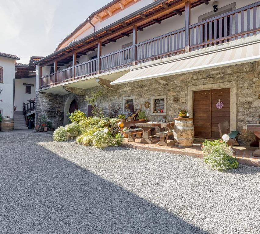 a building with a patio with a table and chairs at Tourist Farm Pri Živcovih in Dutovlje