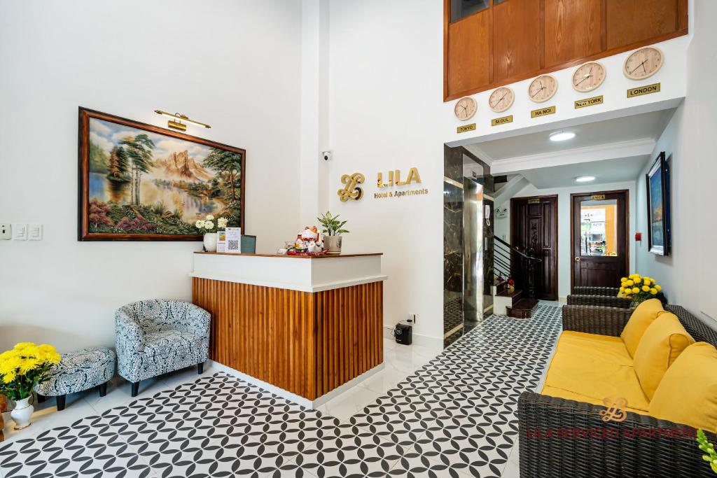 een lobby met een gele bank en 2 stoelen bij LILA Hotel & Apartments in Ho Chi Minh-stad