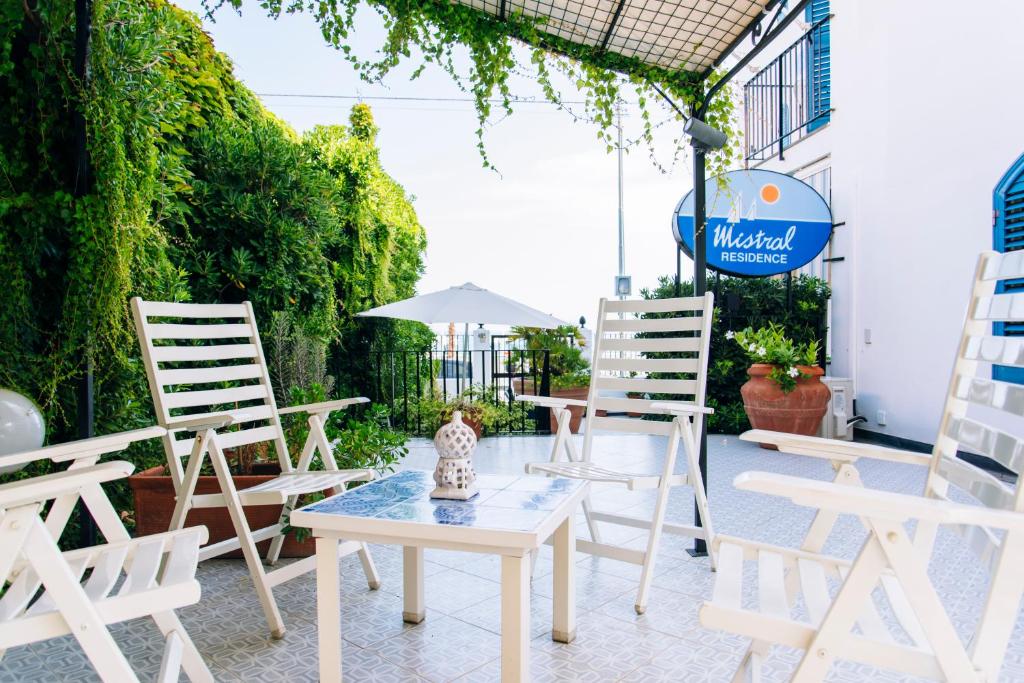 - un ensemble de chaises et d'une table sur une terrasse dans l'établissement Mistral Residence, à Canneto