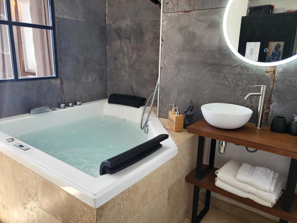 a bathroom with a bath tub and a sink at "The Love Room Bandol" Jacuzzi & Vue Mer in Bandol