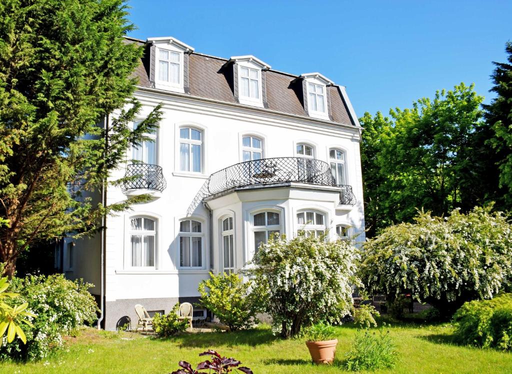 Casa blanca con balcón en la parte superior. en Villa im Ostseebad Baabe, en Baabe