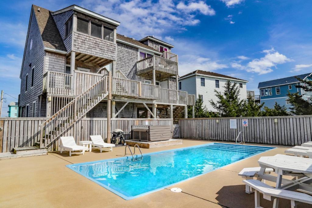 Un patio con piscina y una casa. en Pelican Paradise 770, en Avon