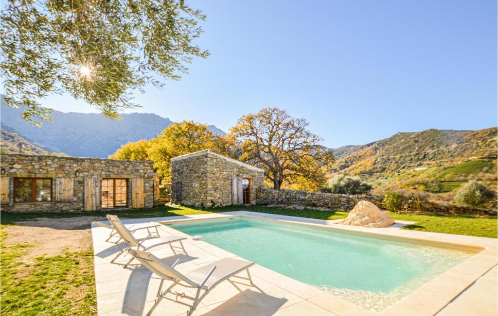una piscina con 2 sillas y una casa en 4 Bedroom Beautiful Home In Feliceto en Feliceto