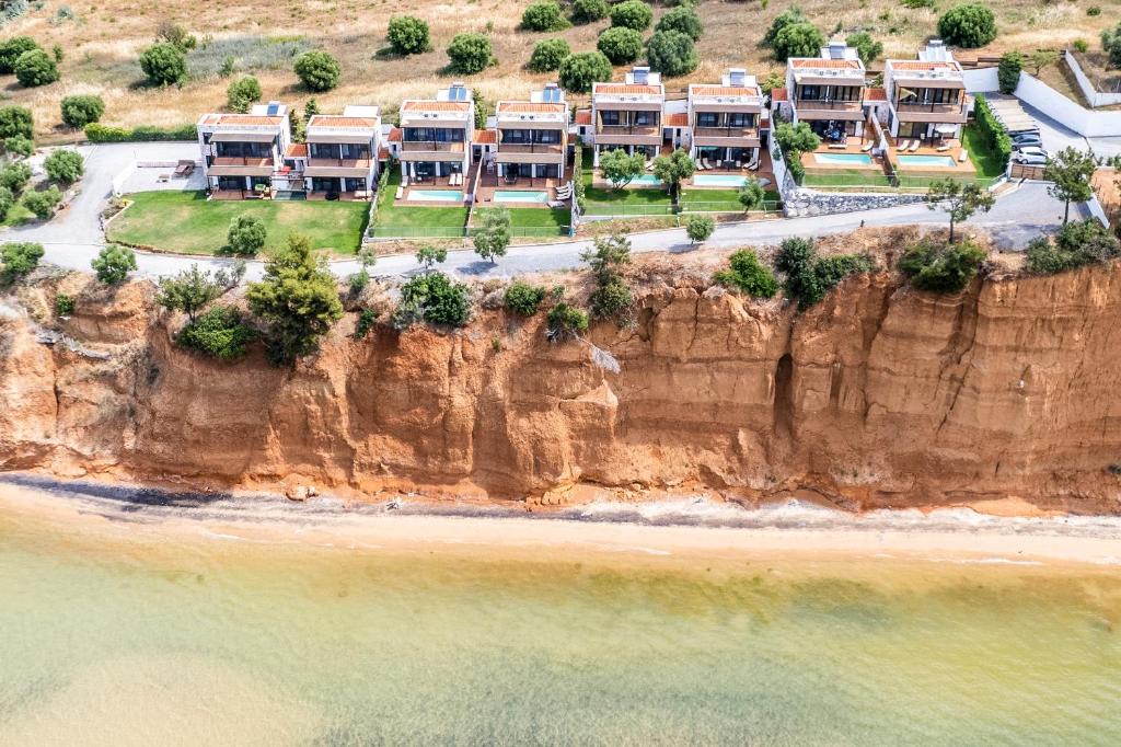 an aerial view of a cliff with houses on the beach at KalMa Villas in Nea Moudania