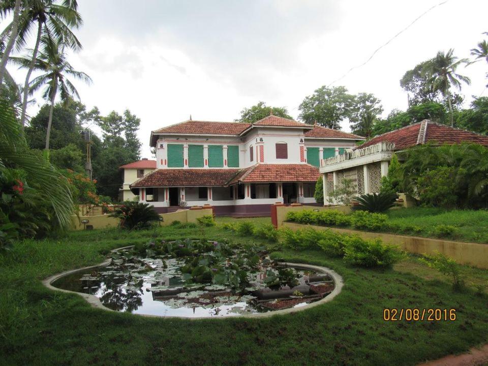 a house with a pond in front of a house at Srivilas in Pudunagaram