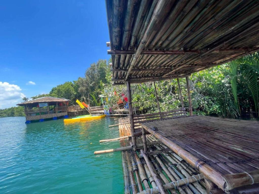 Virgin River Resort and Recreation Spot في Bolinao: رصيف خشبي مع منزل على الماء