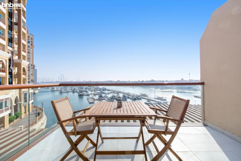 balcón con mesa y sillas y vistas al puerto en bnbmehomes - Studio in The Palm Near Nakheel Mall w Sea View - 205, en Dubái