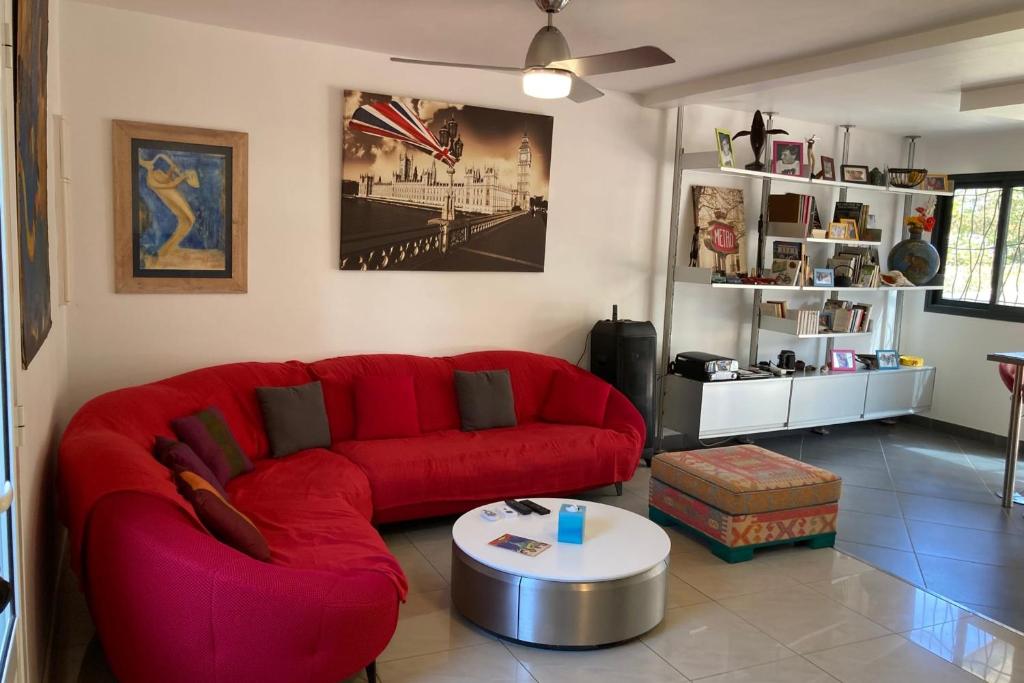 a living room with a red couch and a table at La maison Chanti - La Saline in Le Barrage