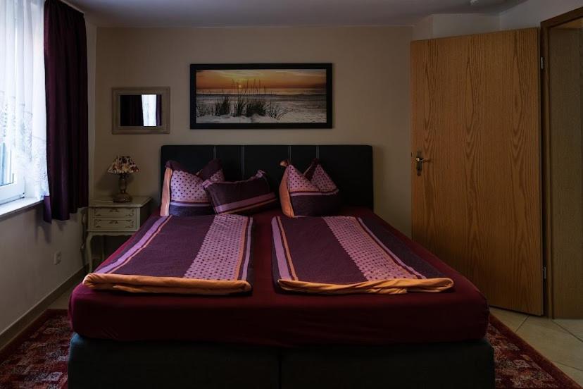 two beds in a bedroom with purple sheets and pillows at Ferienwohnung im Harz in Veckenstedt