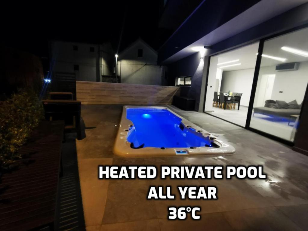 a heated private pool in a house at night at SPA Apartment Vito in Vodice