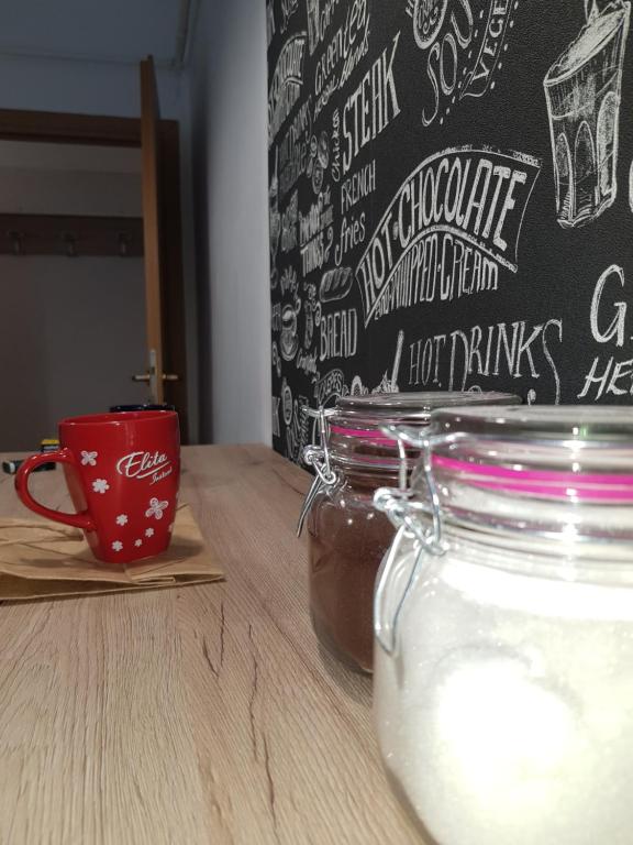 a cup of coffee and a jar of honey on a table at Apartament Simona in Braşov