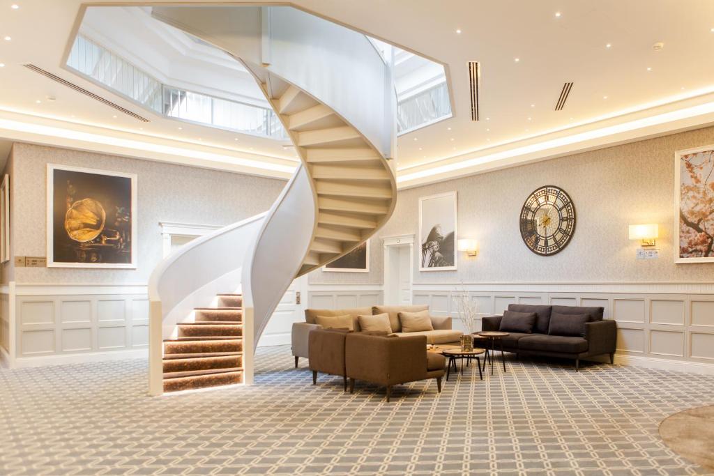 un escalier en colimaçon dans un hall avec des meubles dans l'établissement Promenade Hotel Baku, à Baku