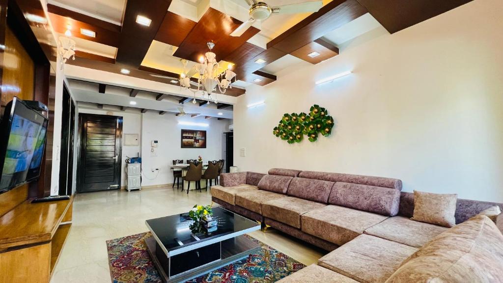 a living room with a couch and a dining room at Olive Service Apartments - Green Park in New Delhi