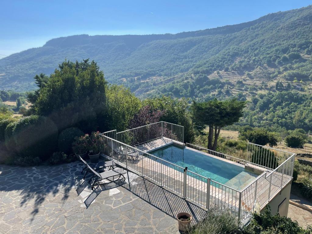a house with a swimming pool and a mountain at Gites en Ardèche avec Piscine et vue magnifique sur la vallée in Rochessauve