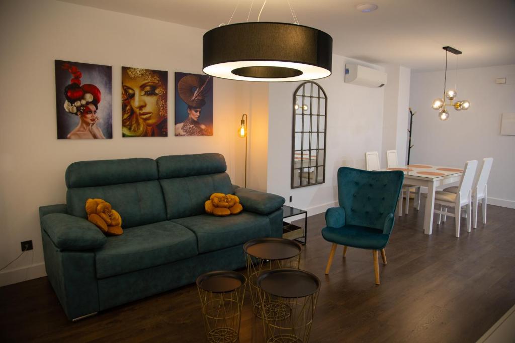 a living room with a green couch and a table at Apartamentos Boutique Cervantes in Plasencia