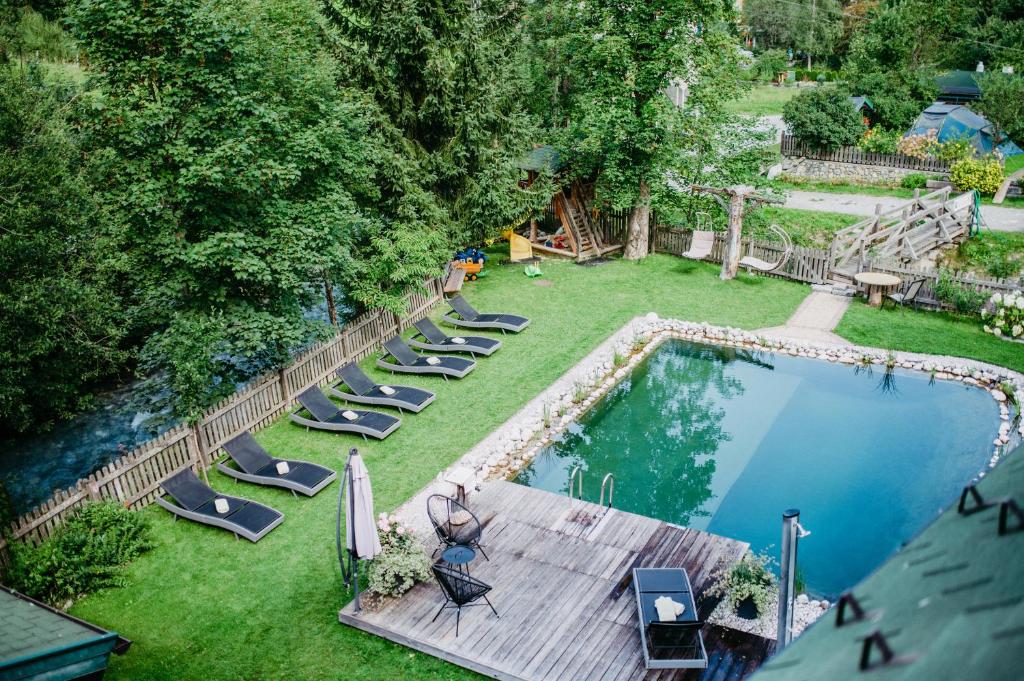 クライナルにあるAppartement Viehhauserのプールとラウンジチェア付きの裏庭の景色を望めます。