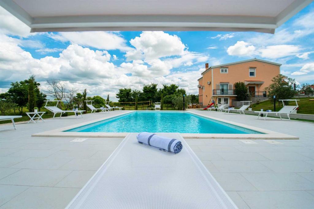 - une piscine avec une serviette au sol dans l'établissement Luxury Villa Maria with large pool, à Suhovare