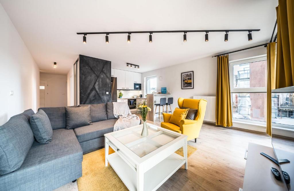 ein Wohnzimmer mit einem Sofa und einem Tisch in der Unterkunft Rent like home - Browary Wrocławskie in Breslau