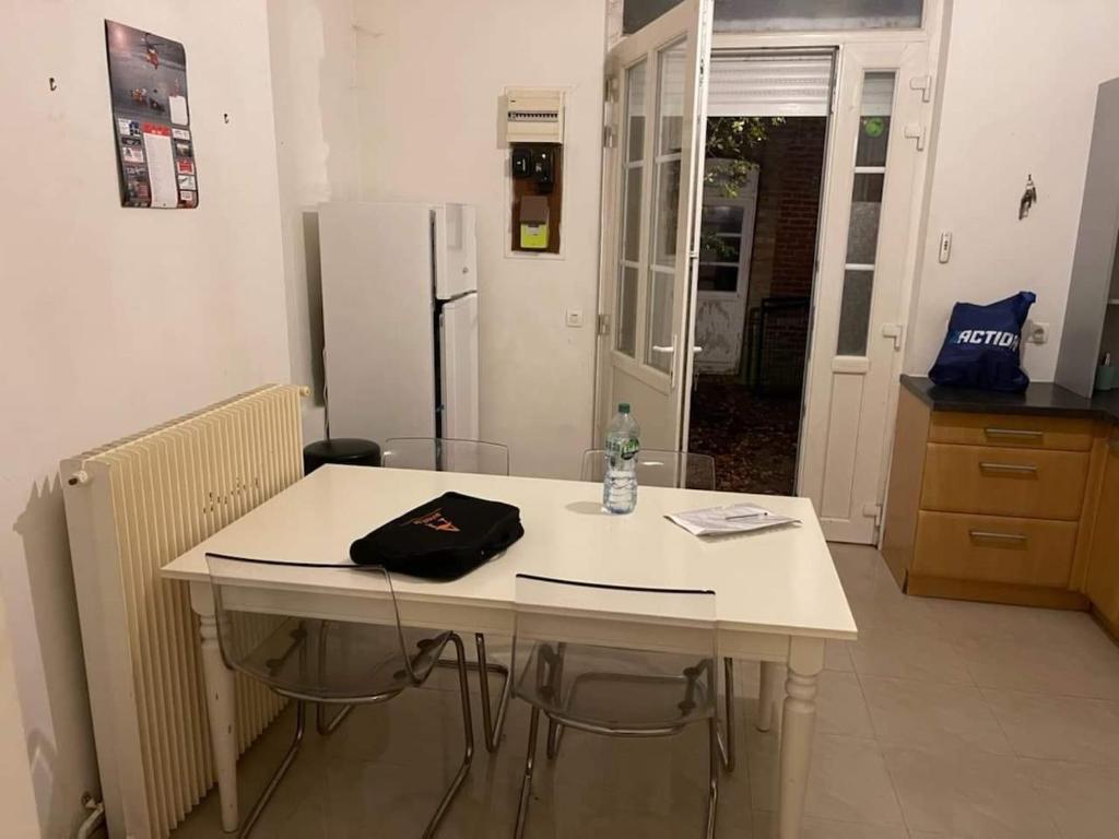 Biały stół w kuchni z lodówką w obiekcie Guibert 17 F2 RDC avec petite terrasse w mieście Caudebec-lès-Elbeuf
