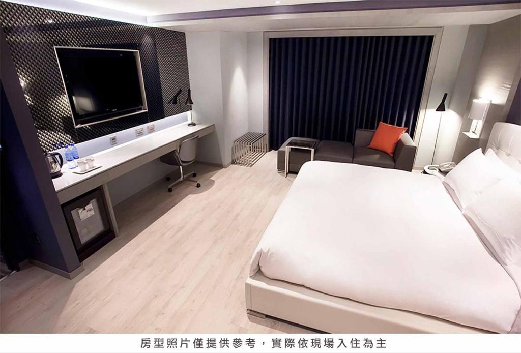 a hotel room with a large bed and a television at Royal Group Hotel Minghua Branch in Kaohsiung