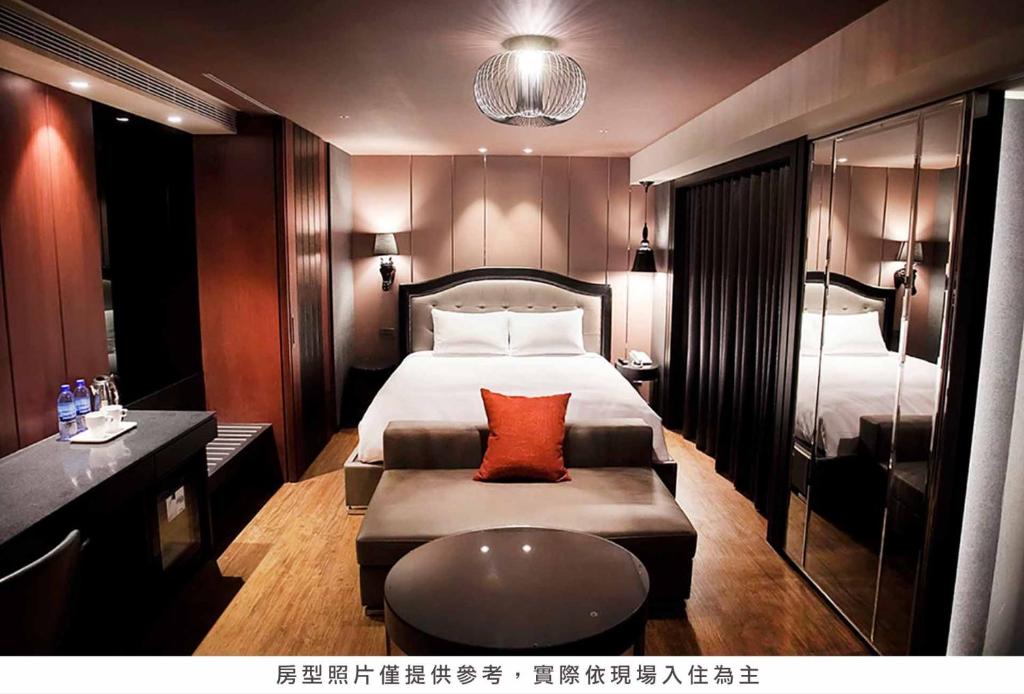 a hotel room with a bed and a couch at Royal Group Hotel Minghua Branch in Kaohsiung