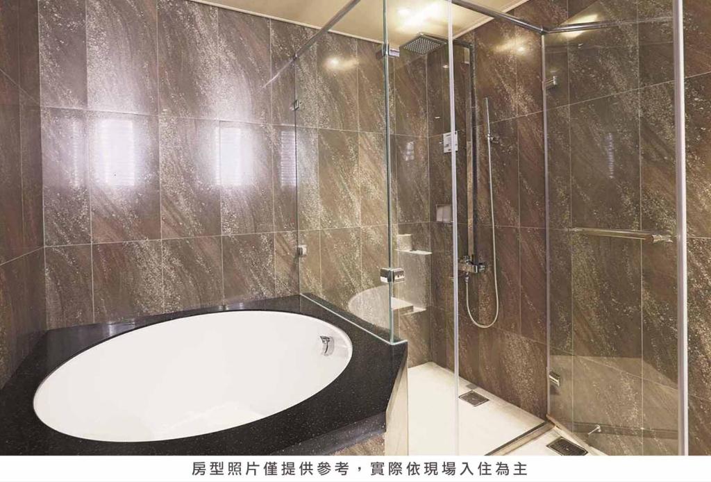 a bathroom with a shower and a bath tub at Royal Group Hotel Minghua Branch in Kaohsiung