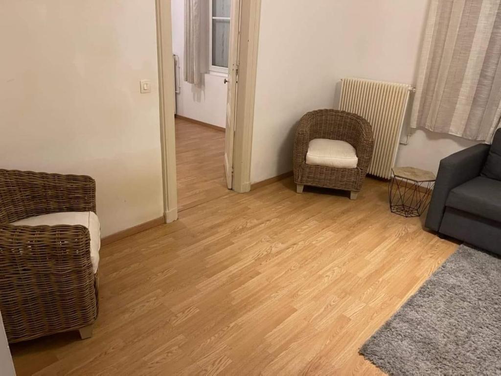 salon z dwoma krzesłami i kanapą w obiekcie Guibert 17 F2 RDC avec petite terrasse w mieście Caudebec-lès-Elbeuf