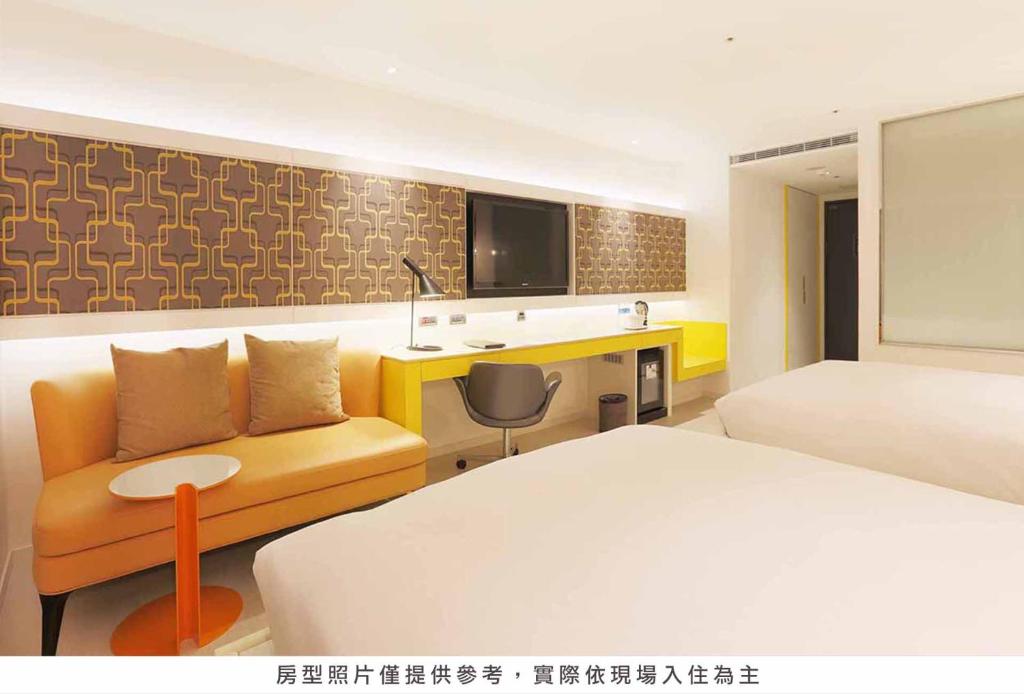 a hotel room with a bed and a couch and a desk at Royal Group Hotel Minghua Branch in Kaohsiung