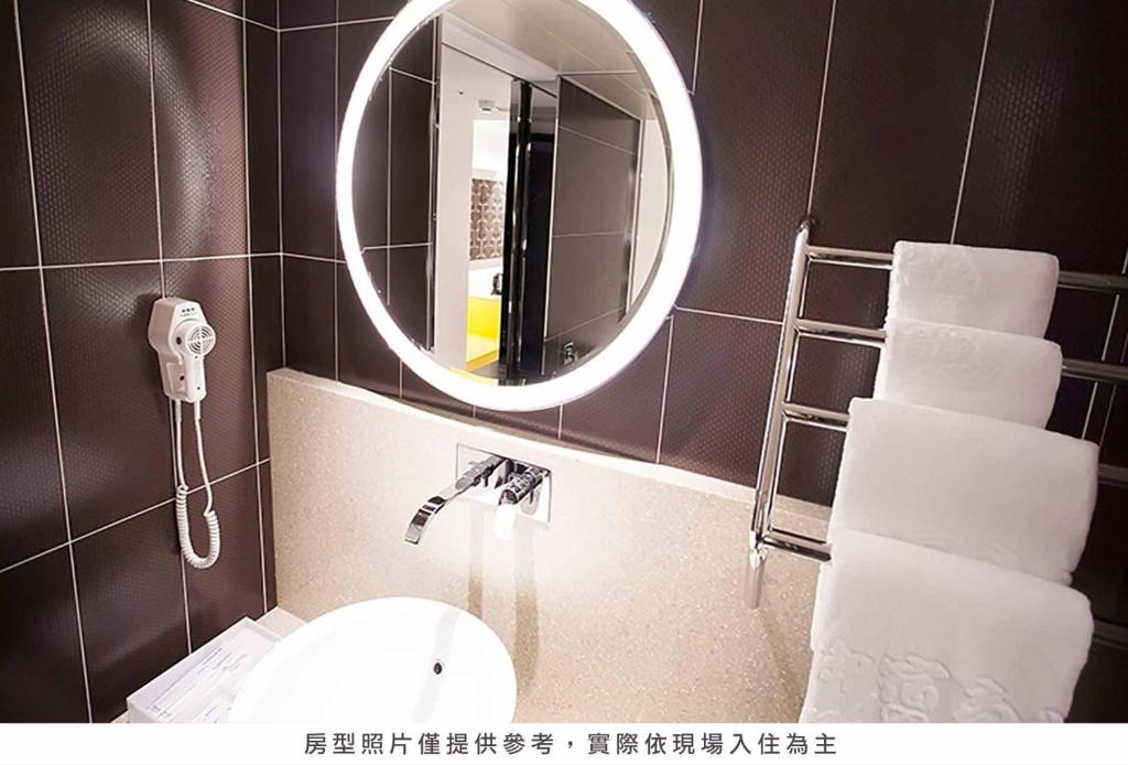 a bathroom with a sink and a mirror at Royal Group Hotel Minghua Branch in Kaohsiung