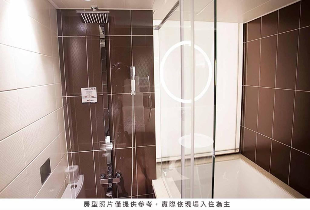 a shower with a glass door in a bathroom at Royal Group Hotel Minghua Branch in Kaohsiung