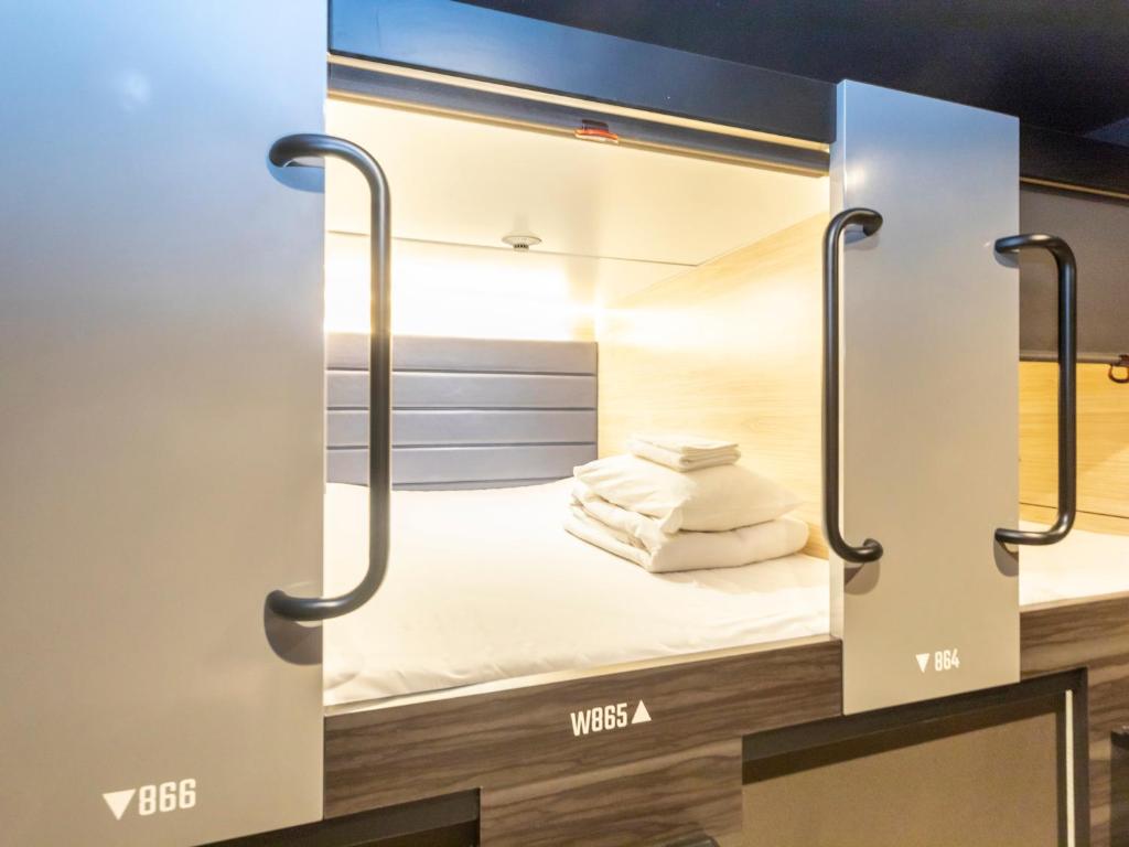 Postel nebo postele na pokoji v ubytování Tabist CapsuleHotel APODS Himeji Station
