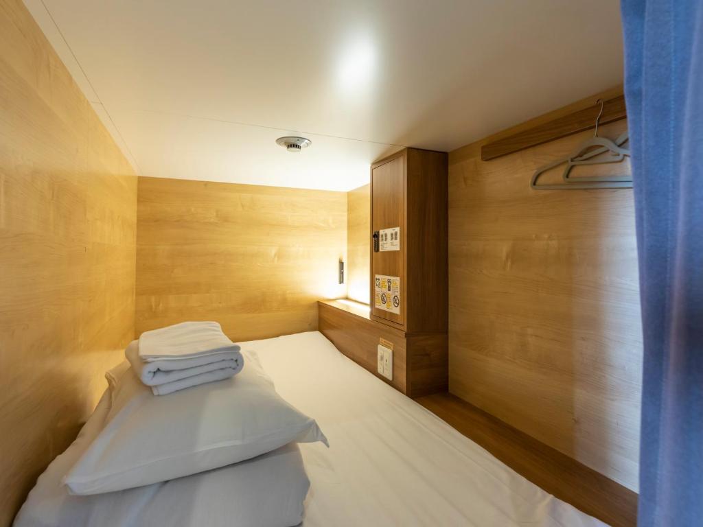 Postel nebo postele na pokoji v ubytování Tabist CapsuleHotel APODS Himeji Station
