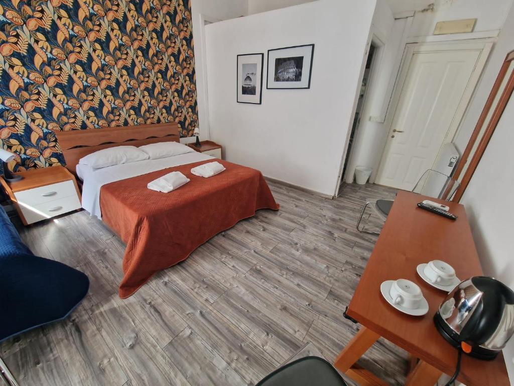 a bedroom with a bed with a red blanket and a table at Roma story in Rome