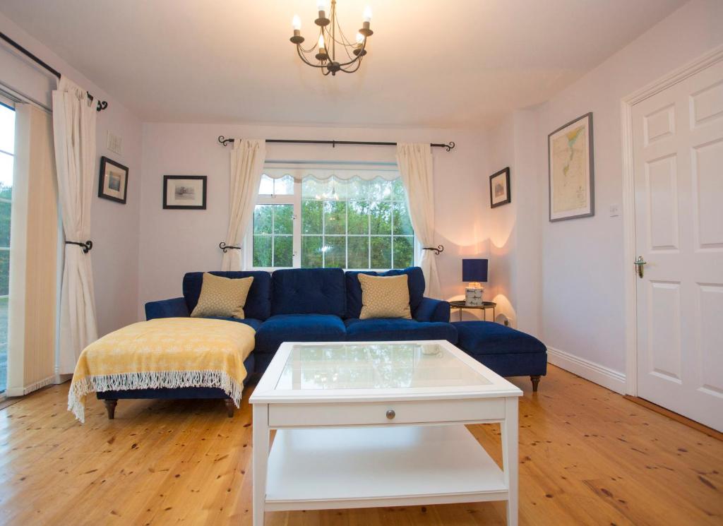 a living room with a blue couch and a table at Saltee View Holiday Home in Kilmore