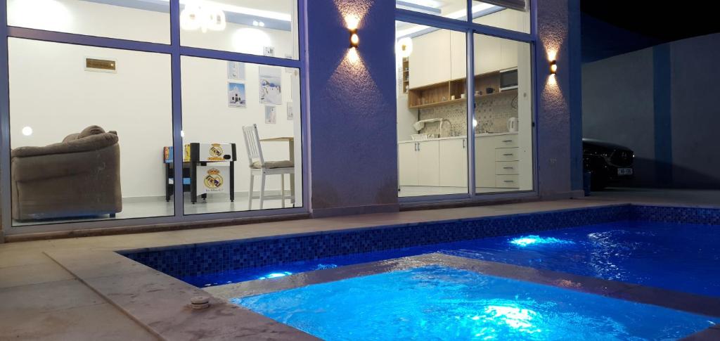 a large swimming pool in a room with windows at Santorini Breeze Chalet in Amman