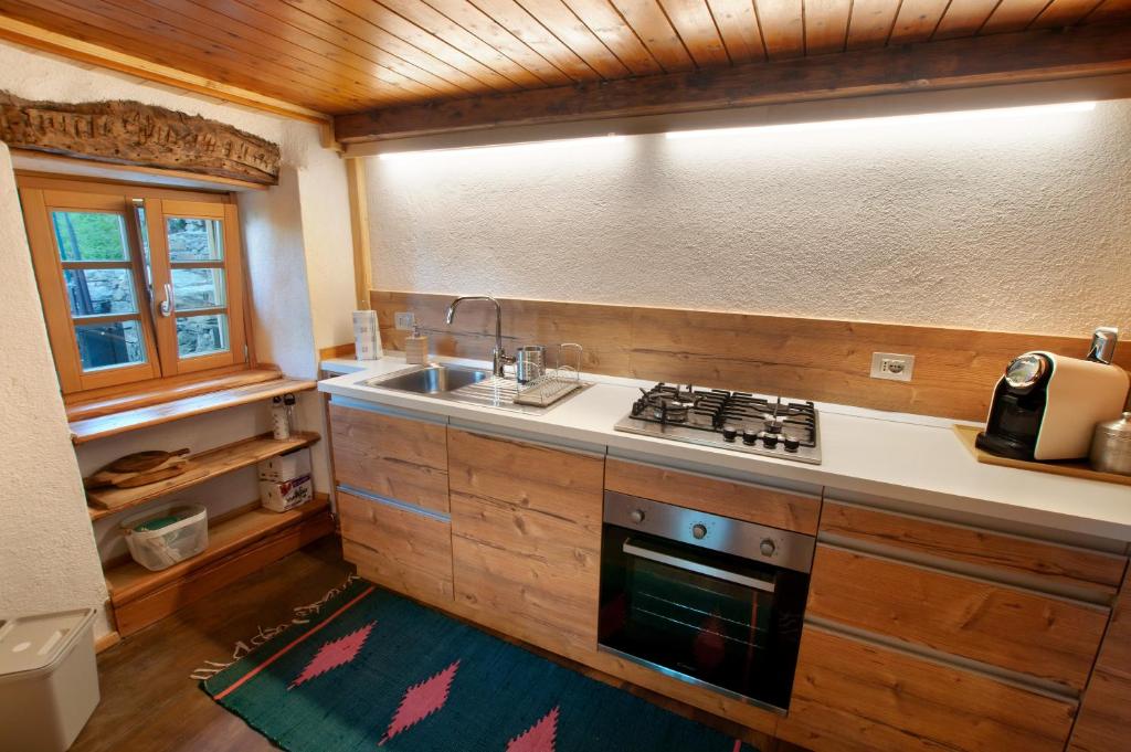 kuchnia ze zlewem i kuchenką górny piekarnik w obiekcie Sweet Somma Mountain Lodge 2 w mieście San Guglielmo