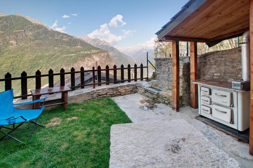 un patio con parrilla, mesa y fogones en Sweet Somma Mountain Lodge en San Guglielmo