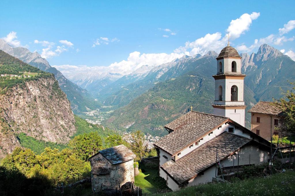 kościół na wzgórzu z górami w tle w obiekcie Sweet Somma Mountain Lodge 2 w mieście San Guglielmo