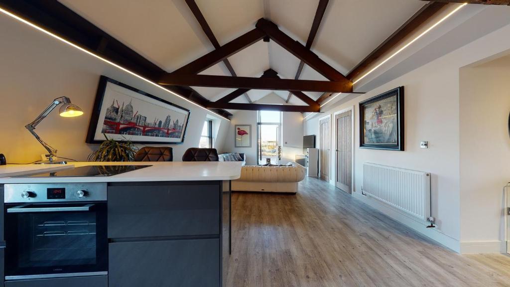 a kitchen with a counter and a living room at Barbican Boutique Luxury Apartments & Rooms, Plymouth in Plymouth