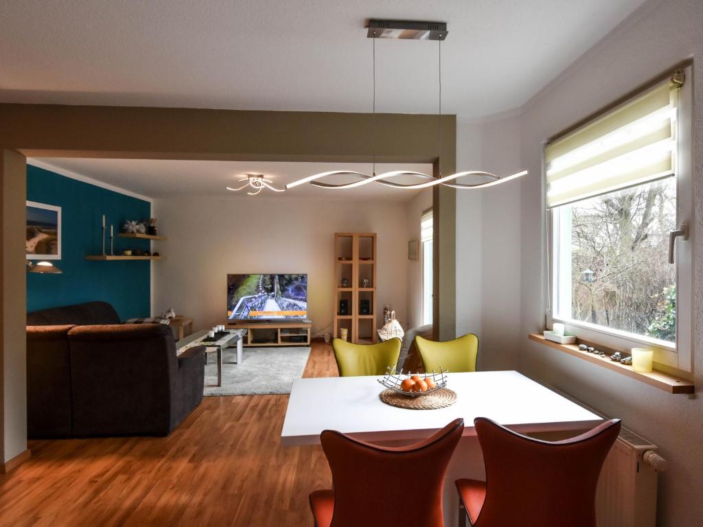 a dining room and living room with a table and chairs at Ferienwohnung Ostseestern in Wiek auf Rügen