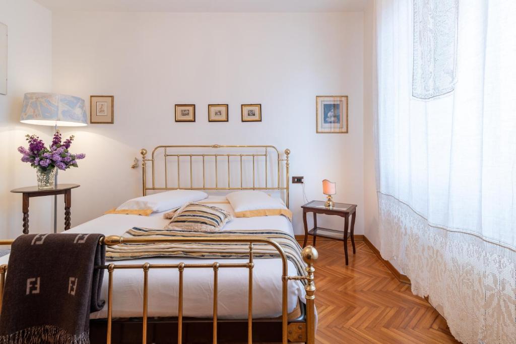 a bedroom with a bed and two tables and a window at Casa Dolce Casa in Montepulciano