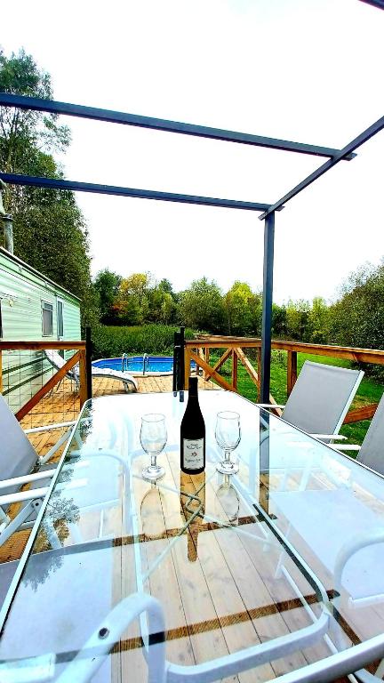 a glass table with a bottle of wine on it at Lac de la Vie in Bressuire