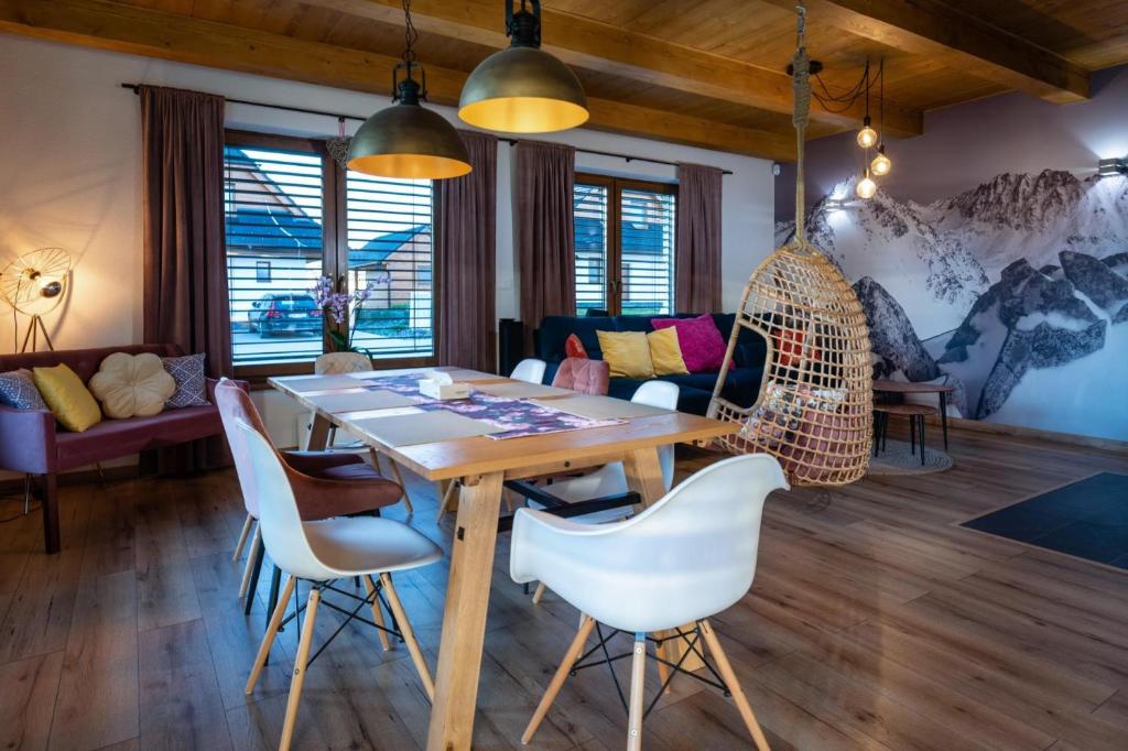 a dining room with a wooden table and chairs at TATRYSTAY Family Villa Rosa in Stará Lesná